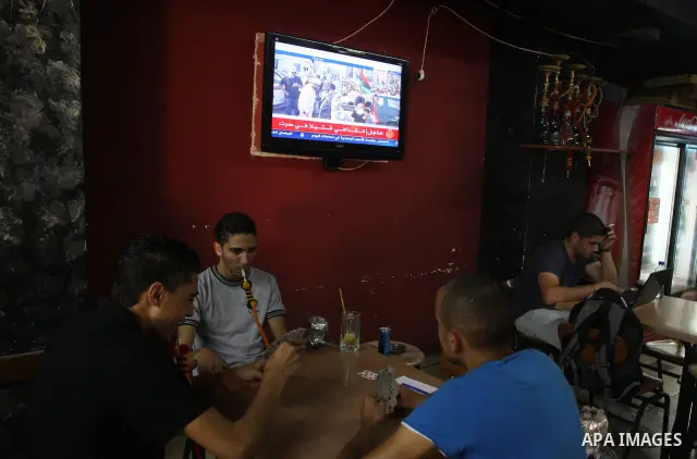 Palestinians watch television news the killing of the Libyan leader,in West Bank, City of Ramallah, on October 20, 2011. Head of the military in the city of Tripoli, "Abdel Hakim Belhadj, " the killing of Libyan leader o...