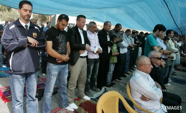 Freed Palestinian prisoners attend Friday prayers in a tent outside the Red Cross headquarters in east Jerusalem on October 21, 2011. The Palestinian Hamas movement exchanged Gilad Shalit, the Israeli soldier who spent m...