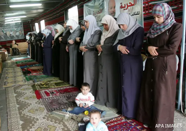 Freed Palestinian prisoners attend Friday prayers in a tent outside the Red Cross headquarters in east Jerusalem on October 21, 2011. The Palestinian Hamas movement exchanged Gilad Shalit, the Israeli soldier who spent m...