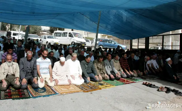 Freed Palestinian prisoners attend Friday prayers in a tent outside the Red Cross headquarters in east Jerusalem on October 21, 2011. The Palestinian Hamas movement exchanged Gilad Shalit, the Israeli soldier who spent m...
