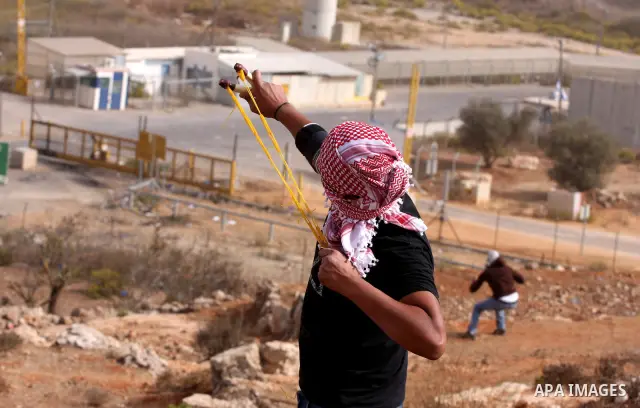 A Palestinian protester hurls stones at Israeli security forces during clashes outside Israeli military prison Ofer near the West Bank city of Ramallah. Friday, Oct. 21, 2011. Photo by Issam Rimawi