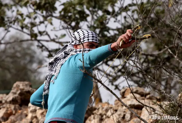 A Palestinian protester hurls stones at Israeli security forces during clashes outside Israeli military prison Ofer near the West Bank city of Ramallah. Friday, Oct. 21, 2011. Photo by Issam Rimawi