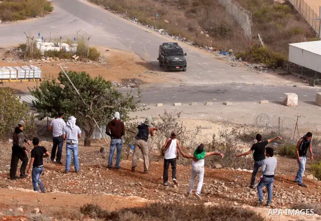 Palestinian protesters hurl stones at Israeli security forces during clashes outside Israeli military prison Ofer near the West Bank city of Ramallah. Friday, Oct. 21, 2011. Photo by Issam Rimawi
