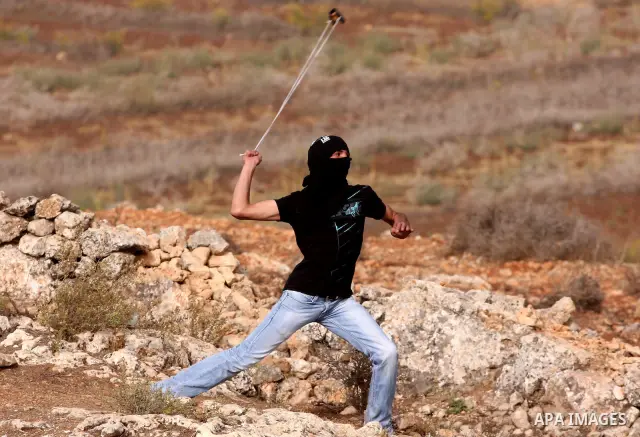 A Palestinian protester hurls stones at Israeli security forces during clashes outside Israeli military prison Ofer near the West Bank city of Ramallah. Friday, Oct. 21, 2011. Photo by Issam Rimawi