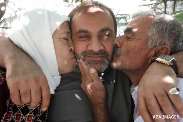 Freed Palestinian prisonerAdnan Mrghma is greeted by relatives and friends after her release from an Israeli jail in the East Jerusalem neighbourhood on October 20, 2011. The Palestinian Hamas movement exchanged Gilad Sh...