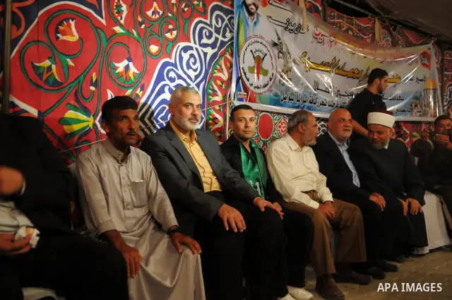 Freed Palestinian prisoner Yehiye Sinwar, a founder of Hamas' military wing, sits between Hamas leaders Ismail Haniya as supporters celebrate the release of hundreds of prisoners following a swap with captured Israeli so...