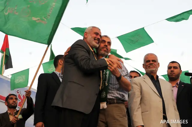 Freed Palestinian prisoner Yehiye Sinwar, a founder of Hamas' military wing, sits between Hamas leaders Ismail Haniya as supporters celebrate the release of hundreds of prisoners following a swap with captured Israeli so...
