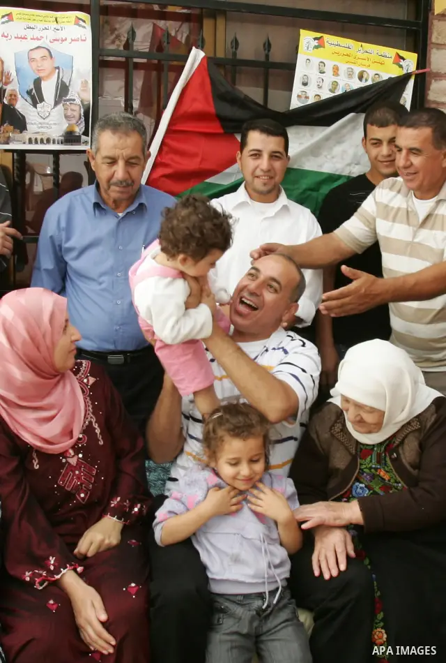 Freed Palestinian prisoner Nasser Abed Rabu is greeted by relatives and friends after her release from an Israeli jail in the East Jerusalem neighbourhood on October 22, 2011. The Palestinian Hamas movement exchanged Gil...