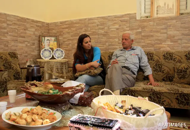 Freed Palestinian prisoner Palestinian Doaa Jayyousi sits with her relatives at her house in the West Bank city of Tulkarem, Sunday, Oct. 23, 2011. Jayyousi, served almost 10 years of three life sentences she was given f...