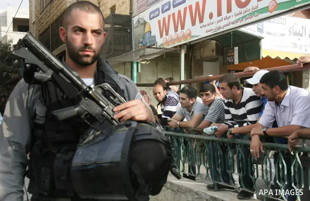 Israeli police officers stand guard during a raid on Al-Quds Development Association headquarters in Beit Hanina on Oct. 23,2011. Israeli forces stormed the association, destroyed some of its contents and confiscated com...