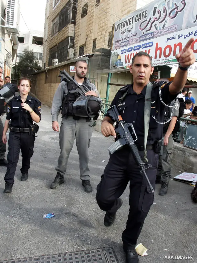 Israeli police officers stand guard during a raid on Al-Quds Development Association headquarters in Beit Hanina on Oct. 23,2011. Israeli forces stormed the association, destroyed some of its contents and confiscated com...