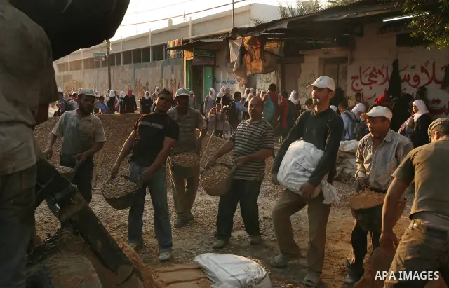 Palestinian labourers work in a residential construction site in Gaza city on Oct. 24,2011 as Palestinians in Gaza Strip suffer from lack of construction materials since the Israeli blockade so they use the tunnels under...