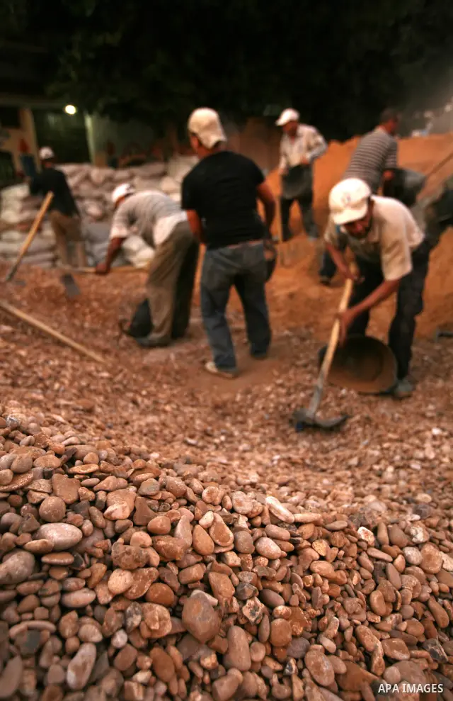 Palestinian labourers work in a residential construction site in Gaza city on Oct. 24,2011 as Palestinians in Gaza Strip suffer from lack of construction materials since the Israeli blockade so they use the tunnels under...