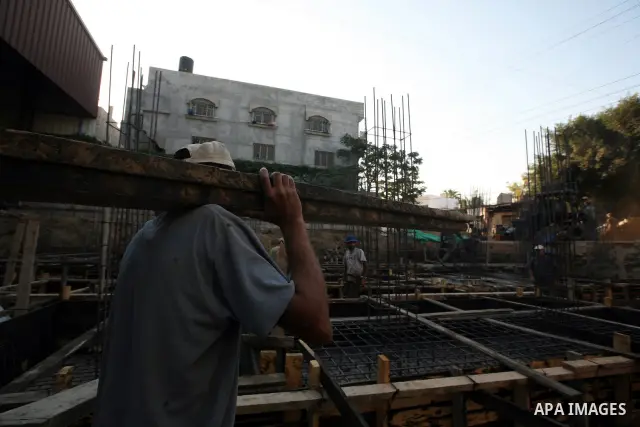 Palestinian labourers work in a residential construction site in Gaza city on Oct. 24,2011 as Palestinians in Gaza Strip suffer from lack of construction materials since the Israeli blockade so they use the tunnels under...