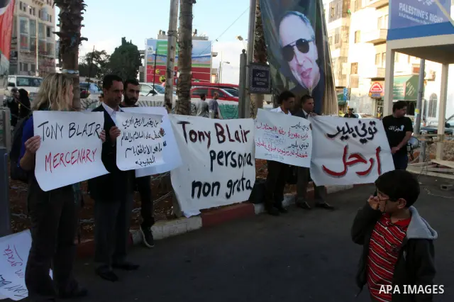 Palestinians hold placards against the policy of the Quartet envoy in the Middle East Tony Blair during a protest in the West Bank city of Ramallah. On October 26, 2011. Palestinian protesters demanded the departure of T...