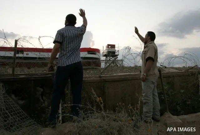Freed Palestinian prisoners wave to Egyptian soldiers during to their visit to a tunnel underground the border between Egypt and southern Gaza Strip town of Rafah on Oct. 26,2011. Prisoners released to the Gaza Strip in...