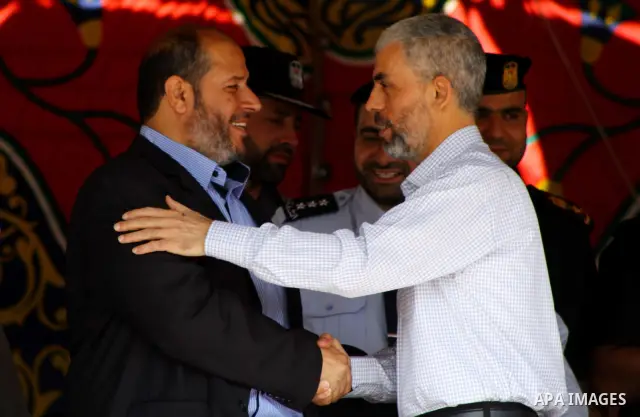 Palestinian Hamas leader Khaleel al-Heah shakes hands with freed prisoner Yahua Senwar during a ceremony organised by Hamas police in Gaza City in front of the media and Palestinian prisoners released in a recent swap be...