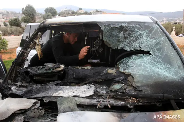A Palestinian man inspects a burnt car in the village of Beit Furik, near the West Bank town of Nablus, on Oct. 27, 2011. Vandals set fire to a car in a West Bank village, and suspicion has fallen on Jewish settlers. Pal...