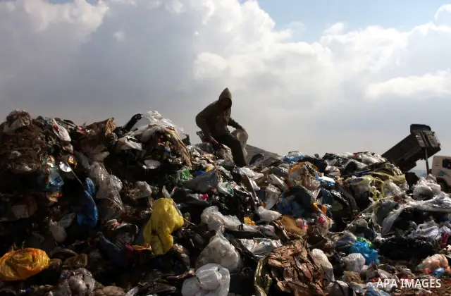 A Palestinian man sift through garbage that was dumped near Ramallah, in the West Bank, 27 October 2011. Palestinians regularly sift through the garbage looking for clothes, metal and any other object thrown out by the n...