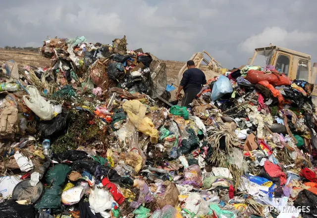 A Palestinian man sift through garbage that was dumped near Ramallah, in the West Bank, 27 October 2011. Palestinians regularly sift through the garbage looking for clothes, metal and any other object thrown out by the n...