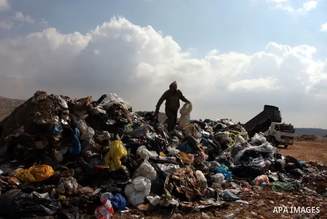 A Palestinian man sift through garbage that was dumped near Ramallah, in the West Bank, 27 October 2011. Palestinians regularly sift through the garbage looking for clothes, metal and any other object thrown out by the n...