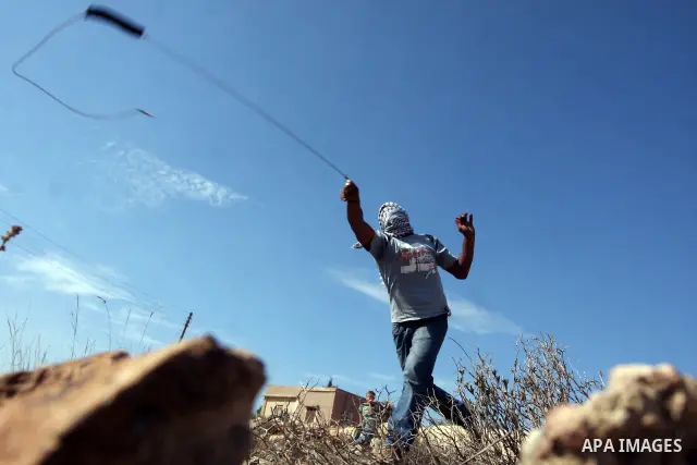 Palestinian youths hurl stones towards Israeli soldiers during clashes following a weekly demonstration against Israeli settlement expansion, in the West Bank village of Nabi Saleh, on October 28, 2011. Photo by Issam Ri...