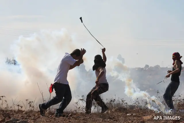 Palestinian youths hurl stones towards Israeli soldiers during clashes following a weekly demonstration against Israeli settlement expansion, in the West Bank village of Nabi Saleh, on October 28, 2011. Photo by Issam Ri...