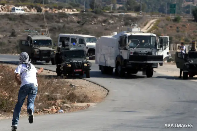 Palestinian youths hurl stones towards Israeli soldiers during clashes following a weekly demonstration against Israeli settlement expansion, in the West Bank village of Nabi Saleh, on October 28, 2011. Photo by Issam Ri...
