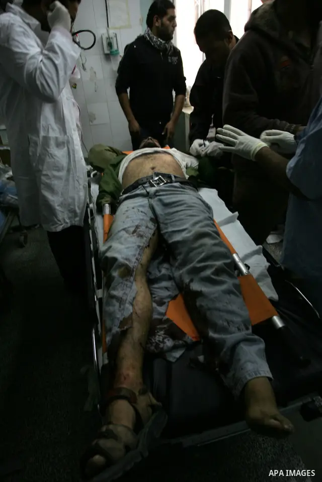 Palestinians carry a wounded militant with the armed wing of the Democratic Front for the Liberation of Palestine (DFLP), into the al-Najar hospital in Rafah on October 30, 2011 after he was injured and another was kille...