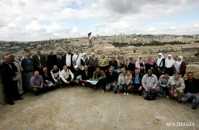 Palestinian pilgrims, who are freed prisoners and their relatives, take pictures before their head to the annual hajj or pilgrimage in the Saudi Muslim holy city of Mecca, in Jerusalem's old city on October 30, 2011. Pho...