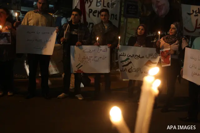 Palestinians hold candles and the Syrian national flag against the Syrian regime and Syrian President Bashar al-Assad in the West Bank city of Ramallah on Oct. 30, 2011. Photo by Issam Rimawi
