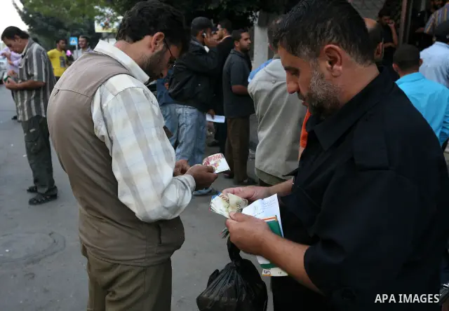Palestinian Authority civil servants gather outside the Islamic Bank in Gaza city on Nov. 03,2011, to withdraw their monthly salaries. Photo by Mahmud Nassar