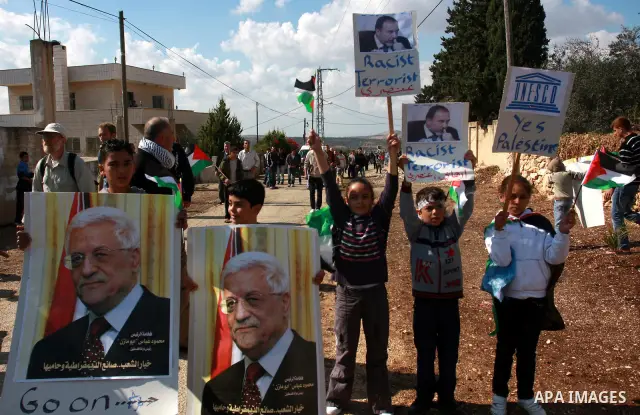 Palestinian demonstrators from the village of Kfar Kadum rally on November 4, 2011 in the Israeli-occupied West Bank as they hold pictures of Palestinian president Mahmud Abbas and Israeli Foreign Minister Avigdor Liberm...