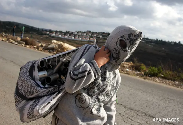 A Palestinian stone thrower wears an improvised "hoodie" during clashes with Israeli soldiers following a weekly demonstration against Israeli settlement expansion, in the West Bank village of Nabi Saleh on November 4, 2...