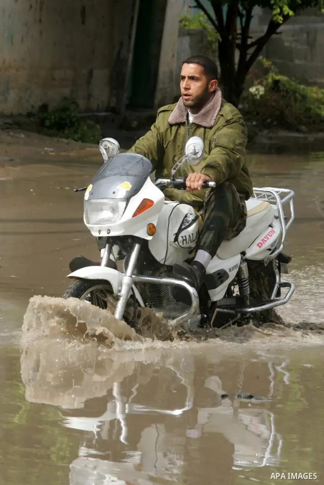 Palestinians cross through the rain water in a street in the Rafah refugee camp southern Gaza Strip on Nov. 4, 2011. Photo by Abed Rahim Khatib