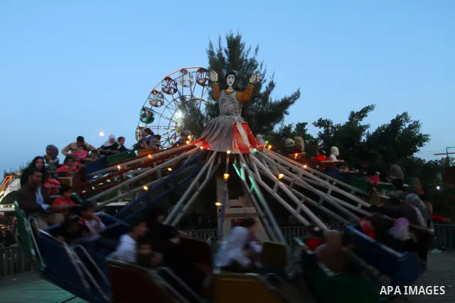 Palestinians enjoy a ride in an amusement park, during Eid al-Adha in Gaza City, Nov. 9, 2011. Muslims worldwide celebrate Eid al-Adha, or the Feast of the Sacrifice, with the sacrificial killing of livestock to commemor...