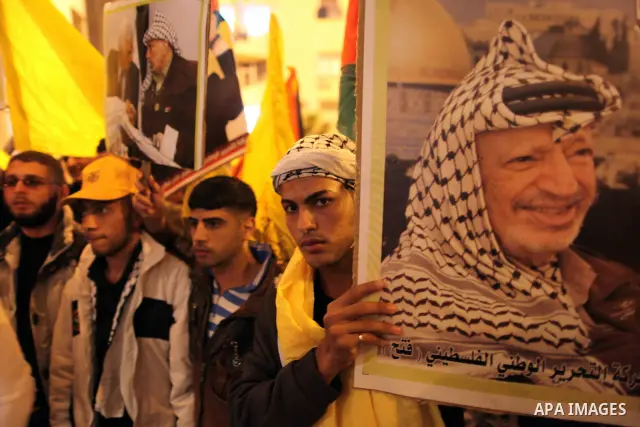 Palestinians hold candles and pictures of late Palestinian leader Yasser Arafat during a ceremony marking the seventh anniversary of his death in Gaza City on November 13, 2011. Photo by Mahmud Nassar