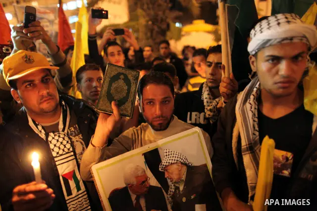 Palestinians hold candles and pictures of late Palestinian leader Yasser Arafat during a ceremony marking the seventh anniversary of his death in Gaza City on November 13, 2011. Photo by Mahmud Nassar