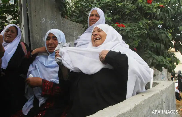 Palestinians mourn the body of Mohammed Al Kelani, a Hamas security officer, during his funeral in Beit Lahiya, northern Gaza Strip, Monday, Nov. 14, 2011. Al Kelani was killed in an Israeli air strike on a Hamas naval p...
