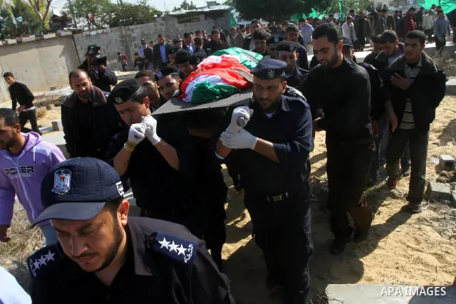 Palestinian police officers carry the body of Mohammed Al Kelani, a Hamas security officer, during his funeral in Beit Lahiya, northern Gaza Strip, Monday, Nov. 14, 2011. Al Kelani was killed in an Israeli air strike on...