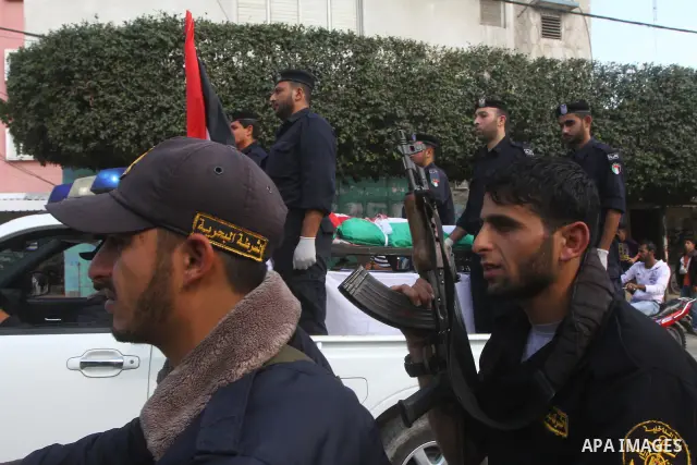 Palestinian police officers carry the body of Mohammed Al Kelani, a Hamas security officer, during his funeral in Beit Lahiya, northern Gaza Strip, Monday, Nov. 14, 2011. Al Kelani was killed in an Israeli air strike on...