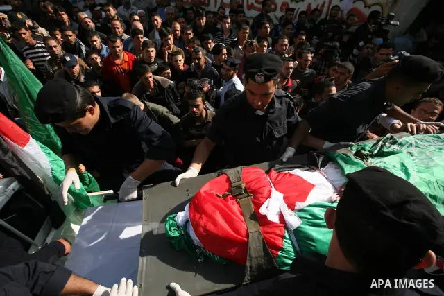 Palestinian police officers carry the body of Mohammed Al Kelani, a Hamas security officer, during his funeral in Beit Lahiya, northern Gaza Strip, Monday, Nov. 14, 2011. Al Kelani was killed in an Israeli air strike on...