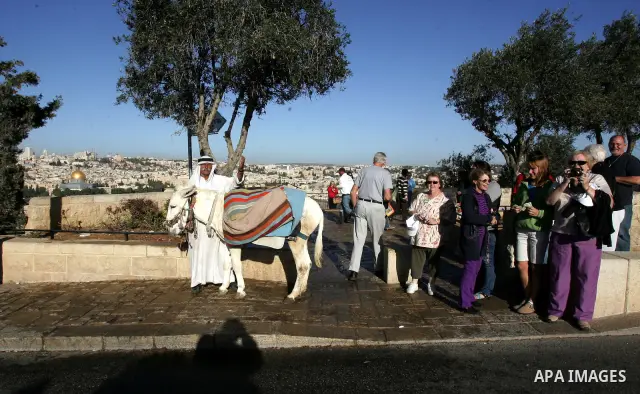 Tourists take pictures outside the Al-Aqsa Mosque compound, Islam's third holiest site, in Jerusalem's Old City on November 14, 2011, the Dome of the Rock is seen in the background. Photo by Mahfouz Abu Turk