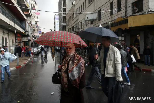 Palestinians walk in a street during heavy rains in the West Bank city of Ramallah on Nov. 14,2011. Photo by Issam Rimawi