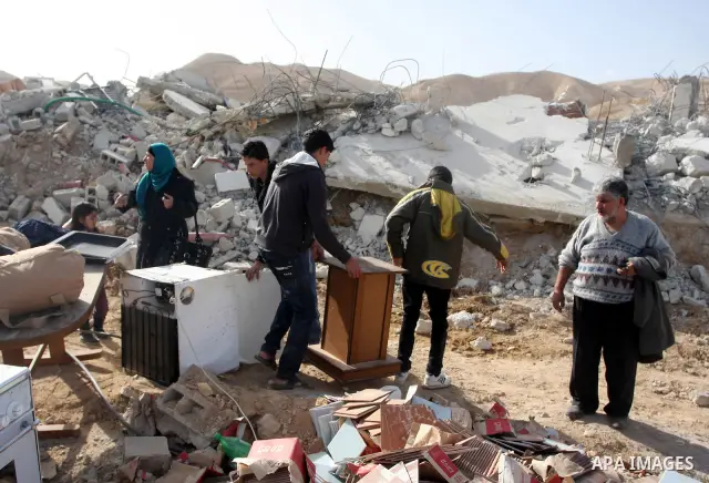 Palestinians check belongings scattered on the ground after Israeli bulldozers razed four Palestinian homes near the ancient city of Jericho on November 15, 2011 with Israel saying they endangered a nearby archaeological...