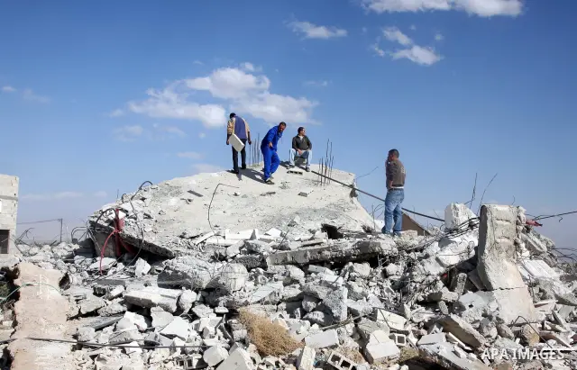 Palestinians check belongings scattered on the ground after Israeli bulldozers razed four Palestinian homes near the ancient city of Jericho on November 15, 2011 with Israel saying they endangered a nearby archaeological...