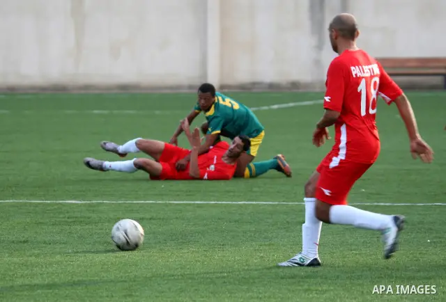 South African (Green) and Palestinian (Red) football players fight for the ball during football match in the West Bank town of Nablus, on Nov. 15, 2011. The match ended in 1-1draw. Photo by Wagdi Eshtayah
