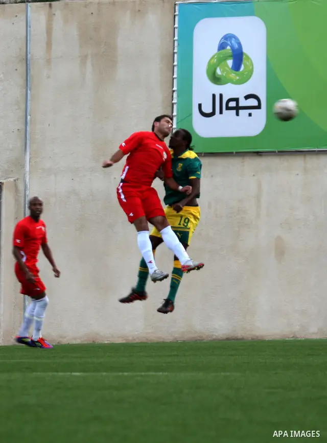 South African (Green) and Palestinian (Red) football players fight for the ball during football match in the West Bank town of Nablus, on Nov. 15, 2011. The match ended in 1-1draw. Photo by Wagdi Eshtayah