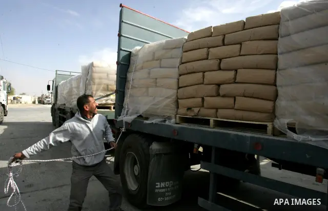 Palestinians check trucks loaded with construction materials at the Rafah crossing which entered through Israel's Kerem Shalom crossing in southern Gaza Strip on November 16, 2011. Israel allowed to enter the constructio...