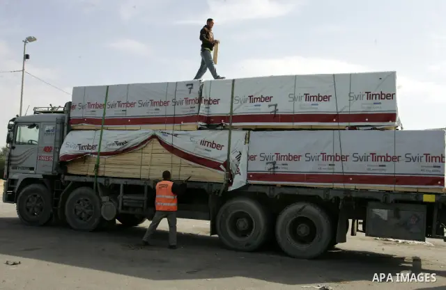 Palestinians check trucks loaded with construction materials at the Rafah crossing which entered through Israel's Kerem Shalom crossing in southern Gaza Strip on November 16, 2011. Israel allowed to enter the constructio...
